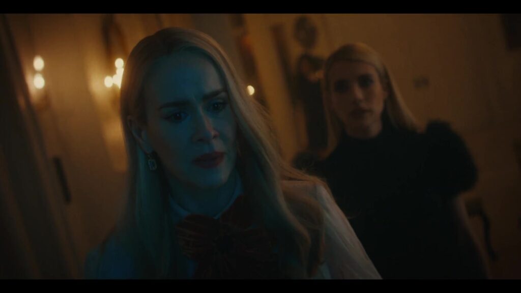Sarah Paulson en Emma Roberts in een donkere gang in American Horror Story 13