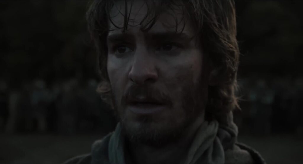 Andrew Garfield met modder op zijn gezicht als de boer in de trailer van The Uprising
