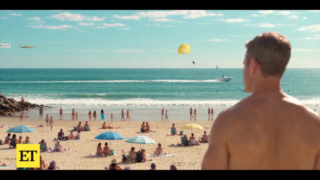 Stephen Amell kijkt uit over een vol strand in de nieuwe Baywatch