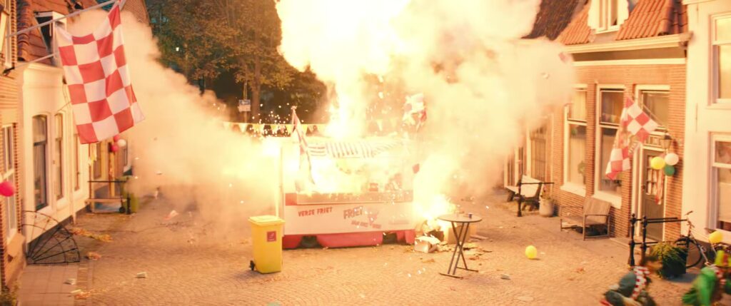 Een ontploffing in een straat vol carnavalsvlaggen in de film Carnaval
