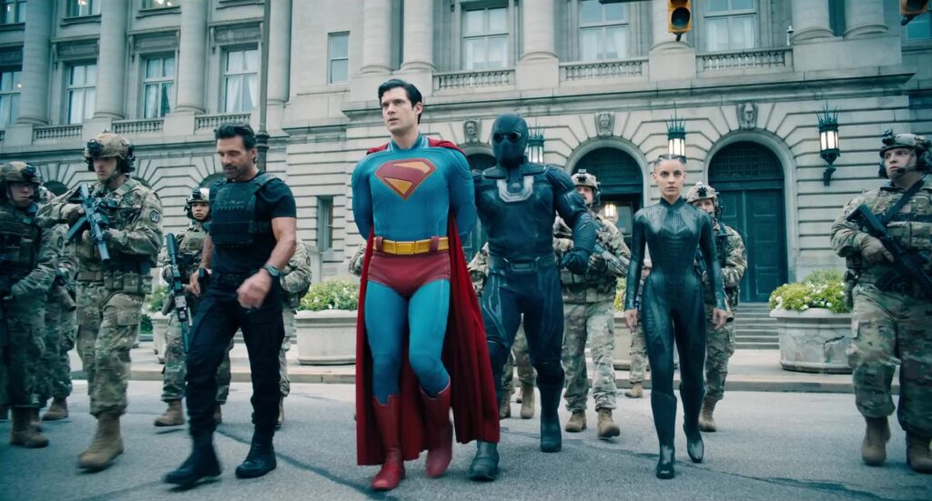 Superman loopt tussen soldaten en andere helden over straat in de film Superman uit 2025