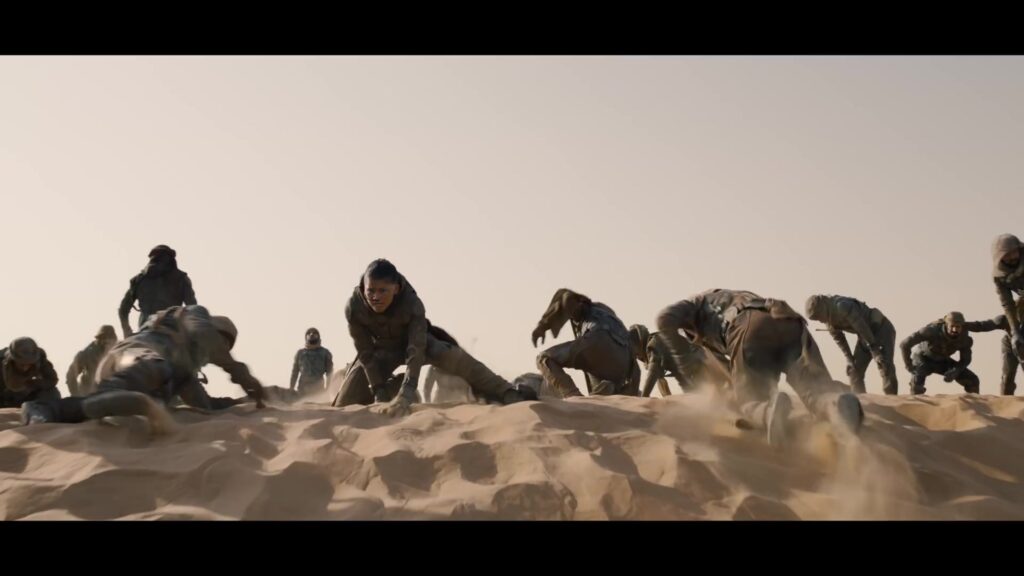 Fremen-strijders kruipen over een zandduin in de trailer van Dune: Part Three