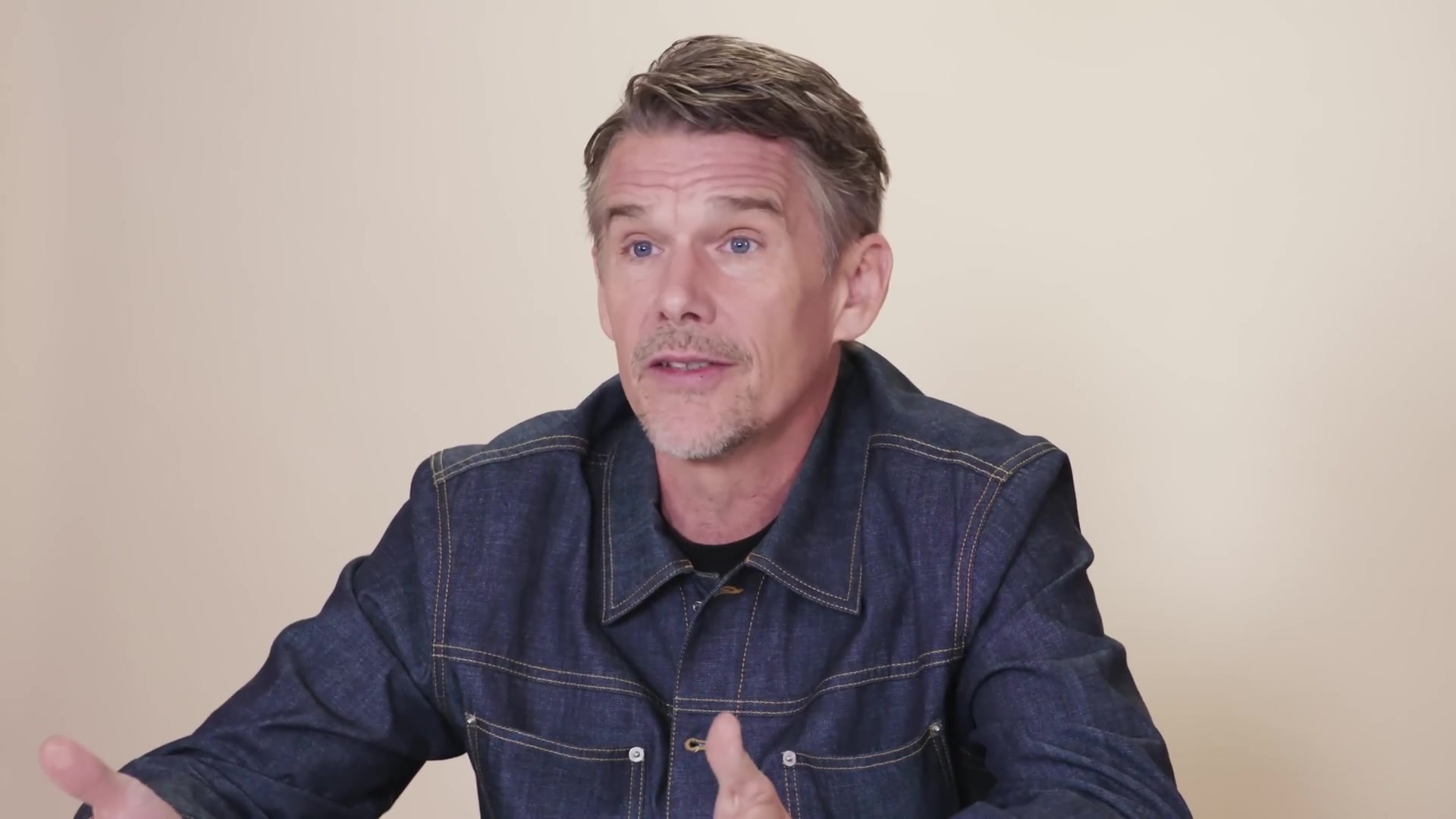 Ethan Hawke in een spijkerhemd tijdens een interview over Blue Moon