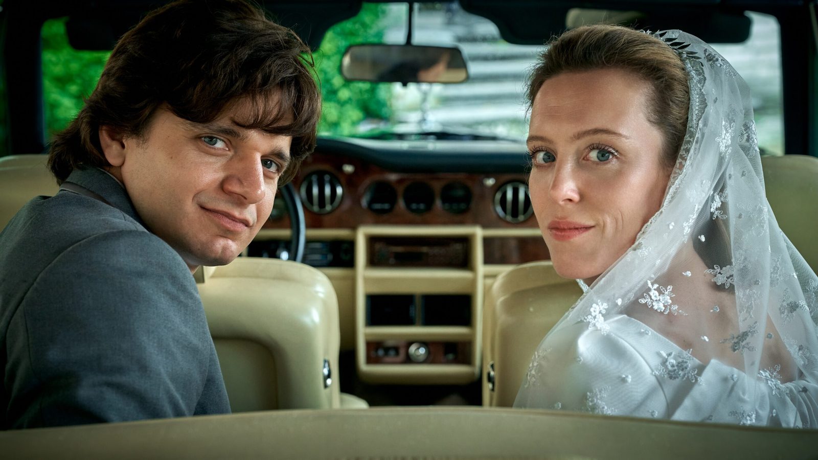 Bruid met sluier en bruidegom achter in een auto in een eerste still uit Mabel & Margarita