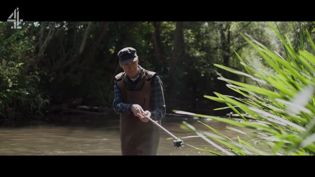 Een man neemt een watermonster uit een rivier in de Britse dramaserie Dirty Business