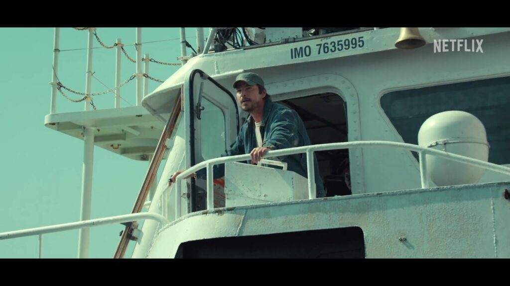 Josh Hartnett staat op het dek van een vissersboot in een still uit de trailer van de Netflix-serie Below