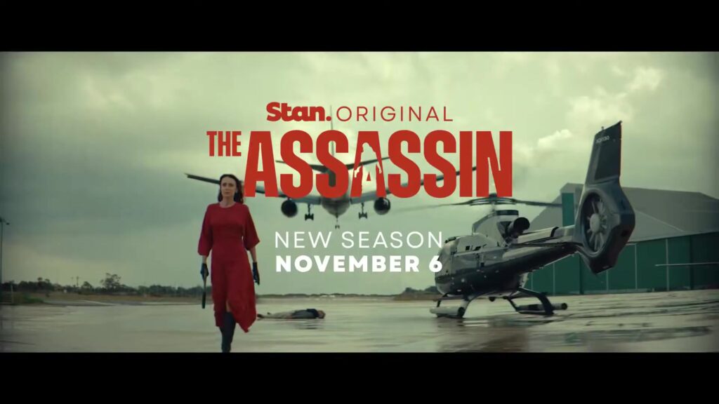 Keeley Hawes in een rode jurk naast een helikopter in de trailer van The Assassin seizoen 2